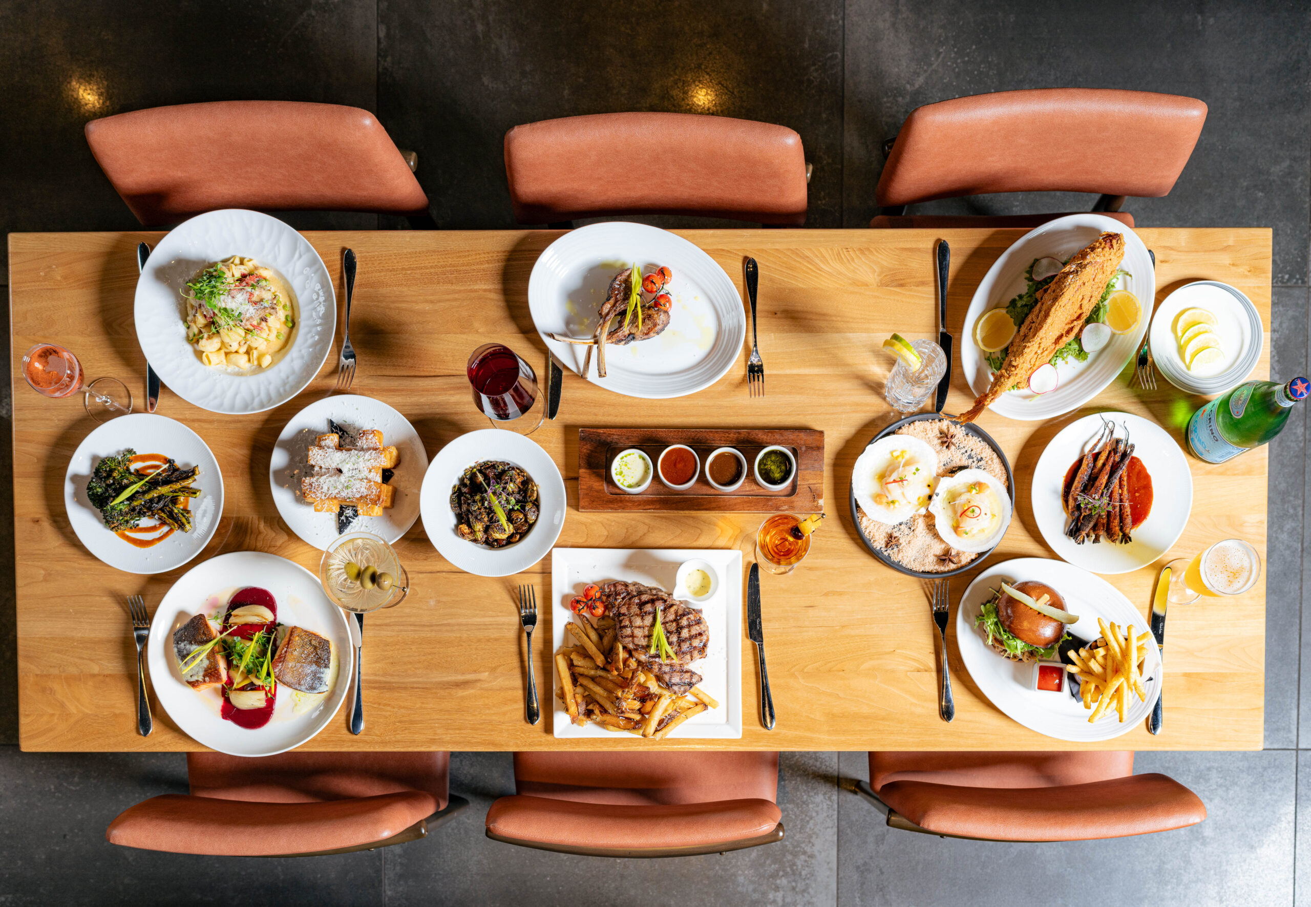 table with multiple plates of food and six chairs