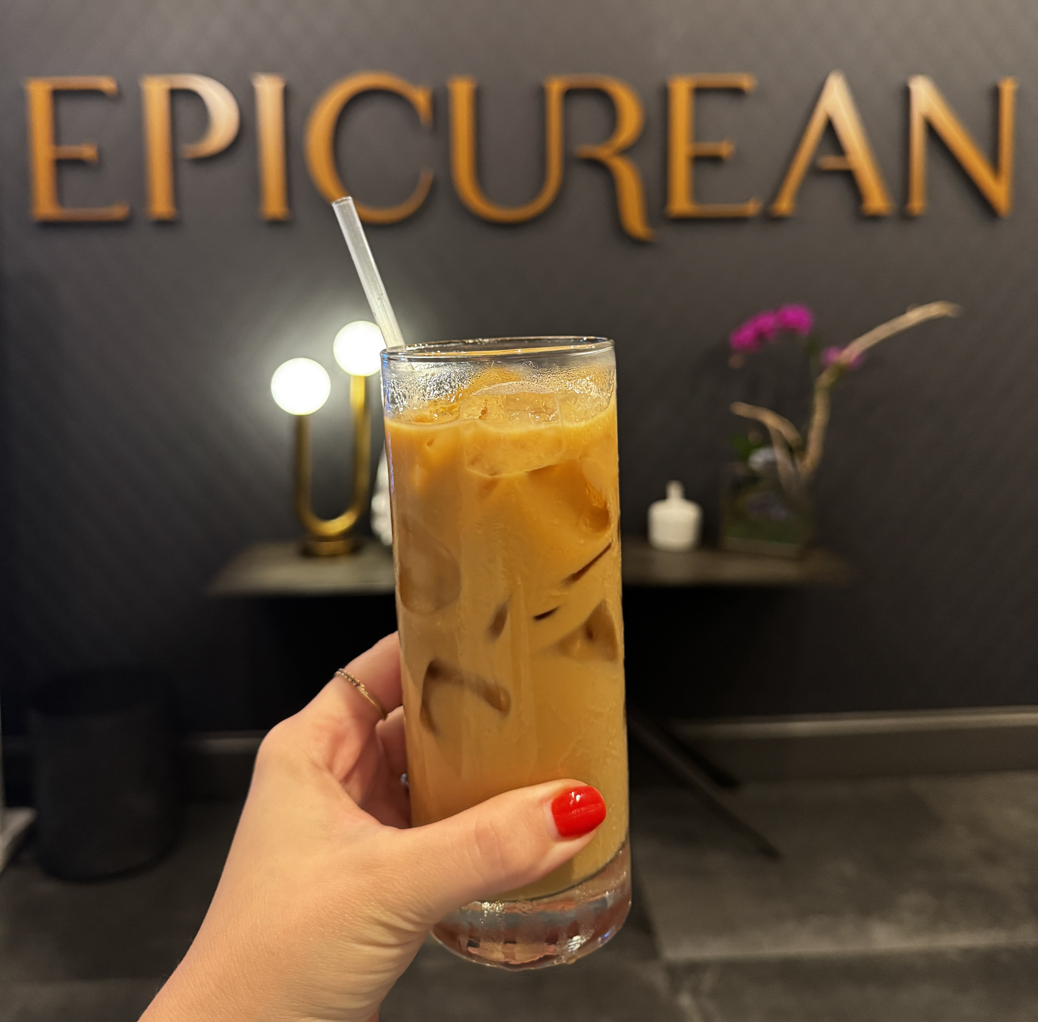 glass of iced coffee in from of Epicurean Atlanta sign