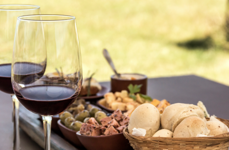a table set with wine, olives and bread
